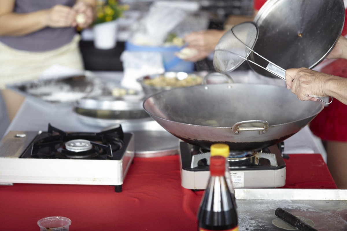 Hawaiian chef preparing traditional dish in a rustic kitchen