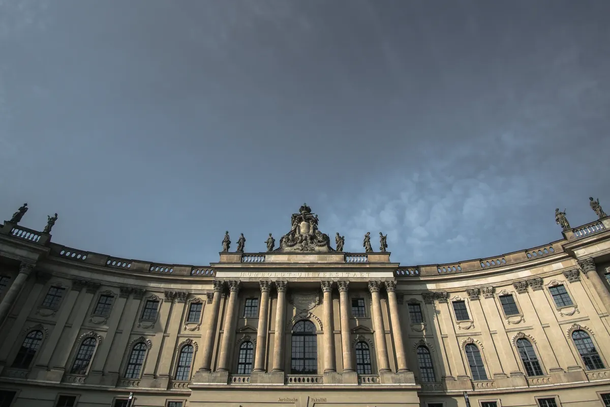 Stunning low-angle view of Humboldt University's historic facade against a cloudy sky in Berlin, Germany.