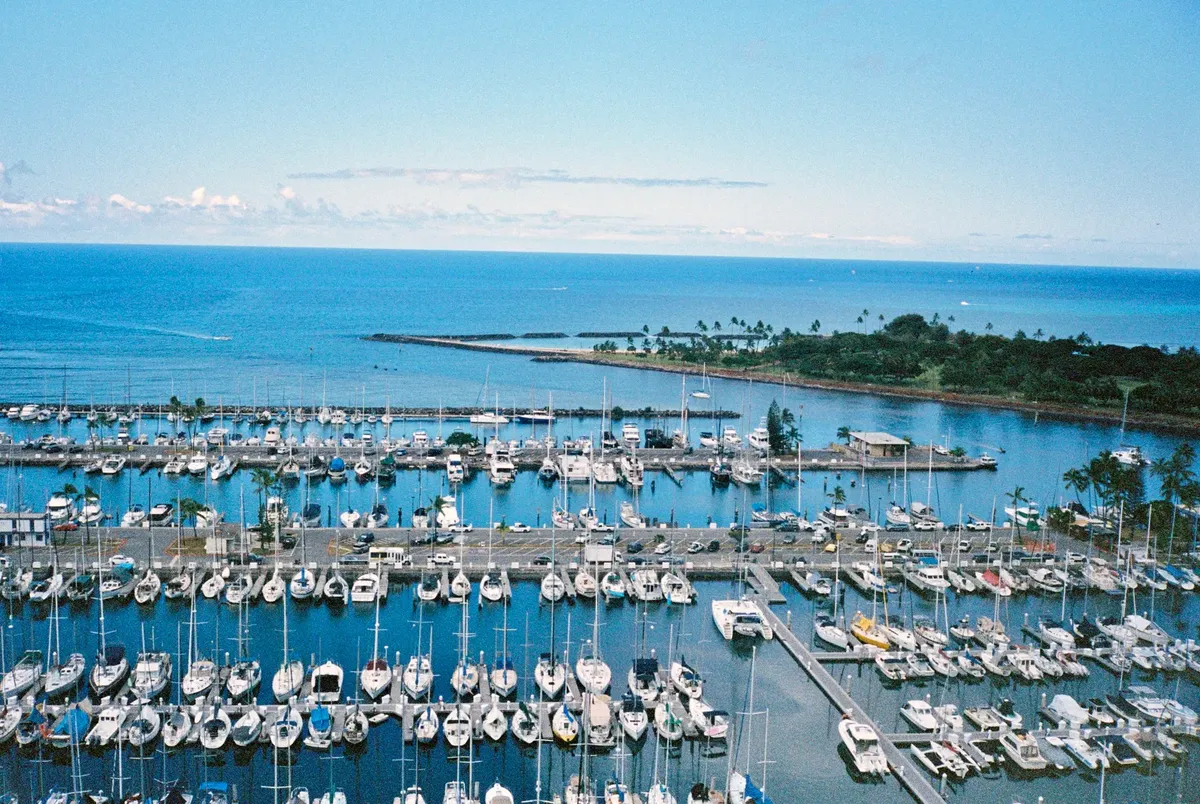 Aerial view of boats docked in Honolulu Harbor, Hawaii, with vibrant ocean scenery.