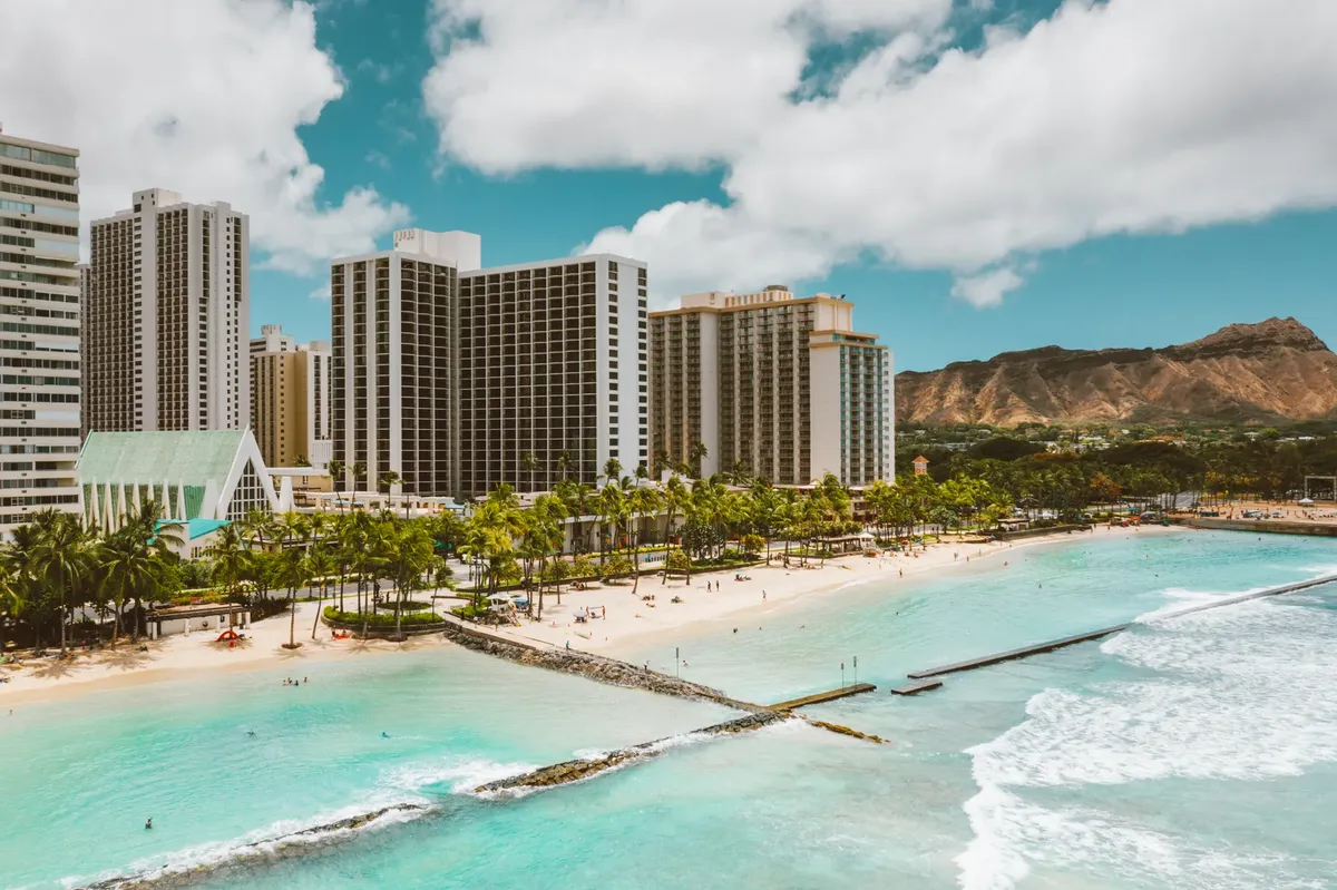 A stunning view of Waikiki Beach's bustling shoreline and the iconic Diamond Head crater in Honolulu, Hawaii.